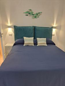 1 cama azul grande con 2 almohadas en Tre Re Appartamento Matima, en Capri