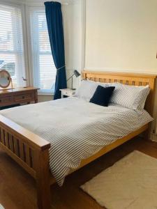 a bedroom with a large wooden bed with blue pillows at No.18 - Ground Floor apartment close to the beach in Cromer
