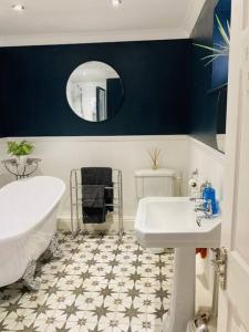 a bathroom with a white tub and a sink at No.18 - Ground Floor apartment close to the beach in Cromer