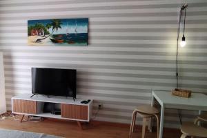 a living room with a television on a striped wall at Figueira Holidays in Buarcos