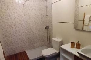 a bathroom with a toilet and a shower and a sink at Figueira Holidays in Buarcos