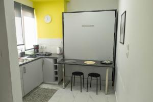 una piccola cucina con tavolo e due sgabelli di ΑΙΘΡΑ Suite ad Atene