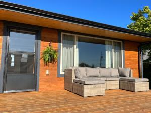 een patio met een bank op een houten terras bij Powell River Ocean View Home in Powell River