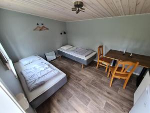 a room with a bed and a table and a bed and a desk at Camp Dammån in Hallen