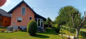 a house with a yard with green grass at Holiday Home Vuković Plitvice Mountain Retreat in Saborsko