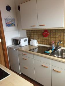 a kitchen with a sink and a microwave at Ferienwohnung Schmidt in Hiddenhausen