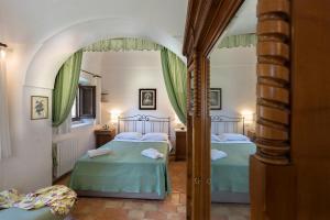 a bedroom with two beds and a mirror at Relais Villa Giusso in Vico Equense +193 photos