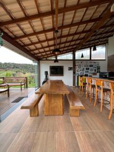 Habitación grande con mesa de madera y bancos. en Casa de Campo no Caravaggio ao lado da Cervejaria Três Santas en Santa Teresa