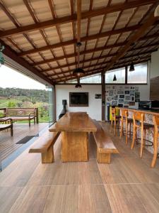 a large room with a wooden table and benches at Casa de Campo no Caravaggio ao lado da Cervejaria Três Santas in Santa Teresa
