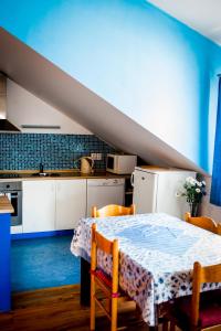 a kitchen with a table with chairs and a blue wall at Apartmány Batelov in Batelov