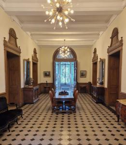 Cette chambre comprend une table, des chaises et un lustre. dans l'établissement Château de Bayssan, à Béziers