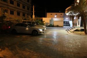 two cars parked in a parking lot at night at Pine Tree in Kanchipuram