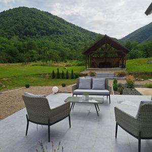 eine Terrasse mit 3 Stühlen und einem Pavillon in der Unterkunft Casa din livada Borlova in Borlova
