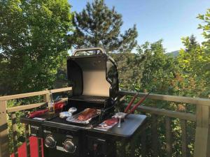 a bbq grill with meat on a deck at Cozy Chalet in the Mont Tremblant Ski Village in Mont-Tremblant