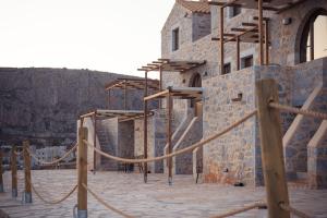 un edificio de piedra con una cuerda alrededor en Monodendri Suites, en Yerolimin