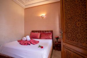 1 dormitorio con 1 cama con 2 toallas en Riad Petite Rose en Marrakech