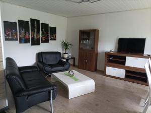 a living room with two chairs and a tv at Ferienwohnung zur Alten Brauerei, free Wi-Fi+Parken, 3 Schlafzimmer, Grillecke in Lehesten
