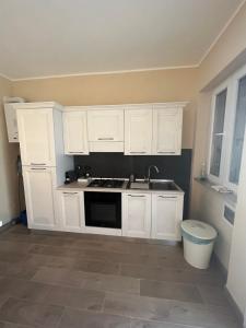 a kitchen with white cabinets and a sink at Cecco Guest house in Pisa