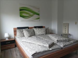 1 cama en un dormitorio con una pintura en la pared en Ferienwohnung zur Alten Brauerei, free Wi-Fi+Parken, 3 Schlafzimmer, Grillecke, en Lehesten