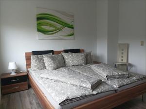 a bed in a bedroom with a painting on the wall at Ferienwohnung zur Alten Brauerei, free Wi-Fi+Parken, 3 Schlafzimmer, Grillecke in Lehesten