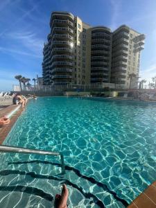 a large swimming pool with people in the water at beautiful oceanfront two bedroom condo in Daytona Beach