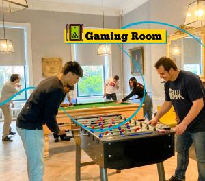 a group of people playing a game of billiard at Leevin Hostel George in Dublin