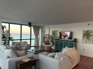 beautiful oceanfront two bedroom condo في دايتونا بيتش: غرفة معيشة مع كنبتين وتلفزيون