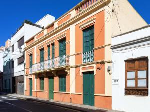 een gebouw met groene deuren en een balkon in een straat bij Live Laguna Center 5 Habitaciones y Terraza in La Laguna