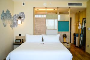 a bedroom with a large white bed in a room at Aloft by Marriott Playa del Carmen in Playa del Carmen