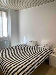 um quarto com uma cama com riscas pretas e brancas em T2 idéalement placé - entre vieux port et plage em Marselha