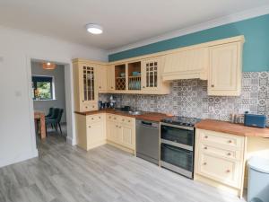 a kitchen with white cabinets and a counter top at Riverside House in Scarborough