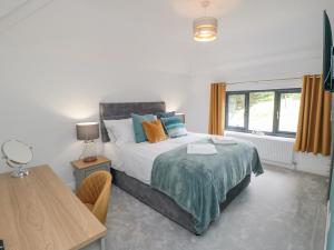 a bedroom with a bed and a table and a window at Riverside House in Scarborough