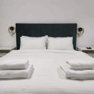 a large white bed with white towels on it at Casa din livada Borlova in Borlova