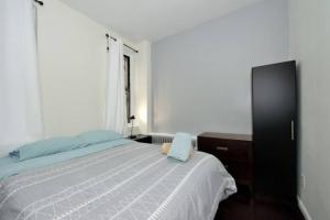 a bedroom with a bed and a dresser and a window at Beautiful 2BR/1BA in Heart of NYC in New York