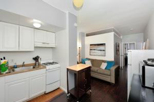 a kitchen and a living room with a couch in it at Beautiful 2BR/1BA in Heart of NYC in New York