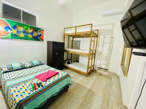 1 dormitorio con 1 cama y 1 litera en Hostal Badillo SV en Cartagena de Indias