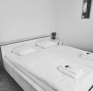 a large white bed with two white towels on it at FeWo D'Rock Arosa im Zentrum by Nature Apartments Switzerland in Arosa