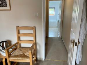 a wooden chair sitting next to a hallway with a door at Aleberry Bed and Breakfast in Lewes