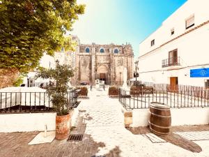 an old building with a gate in front of a street at DUPLEX IN TARIFA'S OLD TOWN in Tarifa