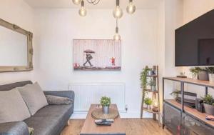 a living room with a couch and a table at Egham Contemporary Stylish Three Bedroom Apartment in Egham