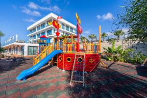 a playground with a slide in front of a building at Blue Sea Karpasia Hotel in Rizokarpaso