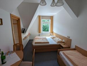 1 dormitorio con 2 camas y ventana en Waldgasthaus & Berghotel Steinerne Renne, en Wernigerode