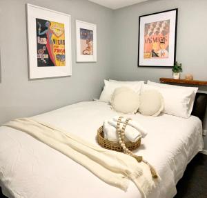 Un dormitorio con una cama blanca con una cesta. en Quite, quaint & private guesthouse, sleeps 6, en Melbourne