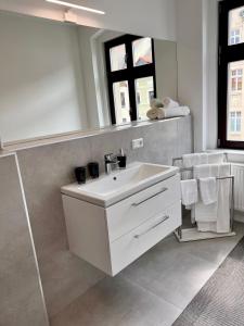 a bathroom with a white sink and a mirror at Apartment Kander 140 m2 mit Massagesessel in Görlitz