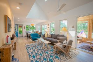 a living room with a couch and a table at Stylish lake home with private beach, dock and firepit for swimming, kayaking, hiking in Barnstead