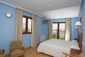 a blue bedroom with a bed and a balcony at Hotel Azul de Galimar in San Vicente de la Barquera
