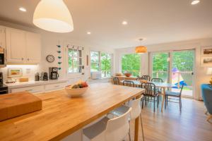 a kitchen and dining room with a table and chairs at Stylish lake home with private beach, dock and firepit for swimming, kayaking, hiking in Barnstead