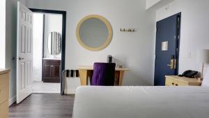 a bedroom with a bed and a desk and a mirror at Hotel Callista in Norwich