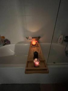 a bathroom with a bath tub with a candle on a tray at Helle Oase am Zürichsee * * * * * in Freienbach