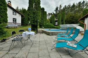 une terrasse avec des chaises, une table et une piscine dans l'établissement Apartmány orlík, à Klučenice